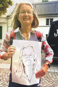 Eine ältere Frau mit einem lebendigen Portrait von ihr.