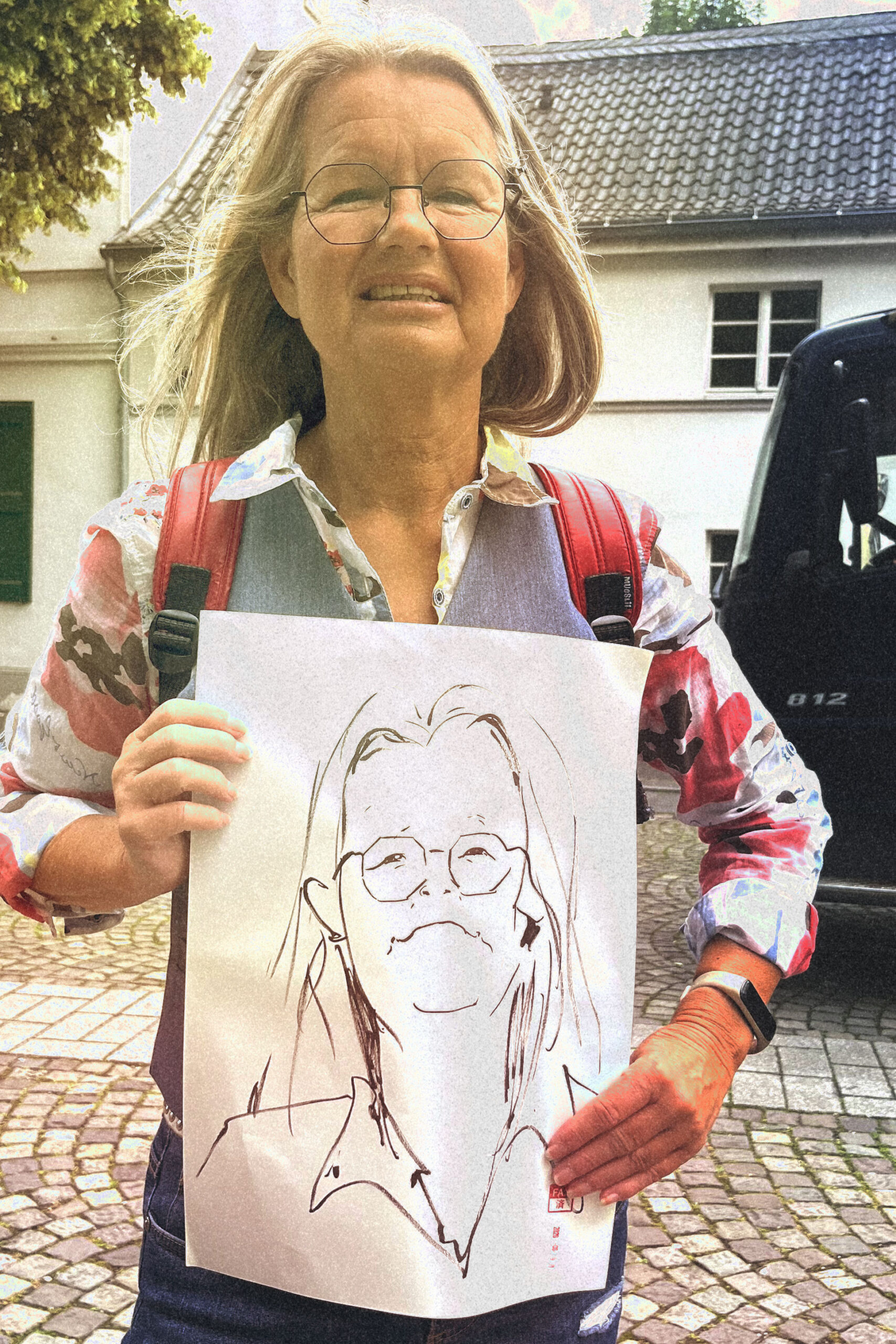 Eine ältere Frau mit einem lebendigen Portrait von ihr.